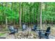 A serene outdoor fire pit area surrounded by mature trees and comfortable Adirondack chairs at 1605 Cascade Overlook, Peachtree City, GA 30269