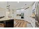 Open-concept kitchen boasts a center island, stainless appliances, white cabinets and access to dining and cooking areas at 1605 Cascade Overlook, Peachtree City, GA 30269