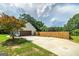 Spacious driveway leading to a garage, complemented by a wooden fence and landscaping at 858 Pates Creek Rd, Stockbridge, GA 30281