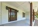 Inviting front porch with a wooden front door and decorative lighting fixtures at 858 Pates Creek Rd, Stockbridge, GA 30281