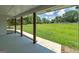 Spacious covered patio with a scenic view of the expansive lawn and mature trees beyond at 858 Pates Creek Rd, Stockbridge, GA 30281