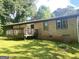 Exterior view of home featuring a wood deck in a large backyard with mature trees at 341 Pineland Sw Rd, Mableton, GA 30126