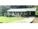 Charming brick home with mature landscaping, gray roof and attached carport at 341 Pineland Sw Rd, Mableton, GA 30126