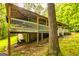 Back exterior view of the house featuring a porch with stairs and mature trees at 107 Trisha Ln, Grantville, GA 30220