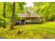 Exterior shot of the back of the house featuring a large deck and a yard with mature trees at 107 Trisha Ln, Grantville, GA 30220