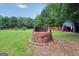 Features a brick fire pit, offering a cozy outdoor gathering space and lush greenery at 250 Stallsworth Rd, Mcdonough, GA 30252