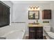 Well-lit bathroom with a soaking tub, granite vanity, and classic fixtures at 250 Stallsworth Rd, Mcdonough, GA 30252