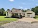 Exterior view of home, featuring a covered porch, lush lawn, and spacious driveway at 250 Stallsworth Rd, Mcdonough, GA 30252