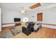 Well-lit living room boasts a ceiling fan, flat screen TV, gray sofa, and hardwood floors at 250 Stallsworth Rd, Mcdonough, GA 30252