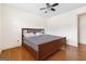Bedroom with hardwood floors, ceiling fan, window with blinds, and a wooden bed frame at 5436 Ahyoka Dr, Morrow, GA 30260