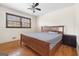 Bedroom with hardwood floors, ceiling fan, window with blinds, and a wooden bed frame at 5436 Ahyoka Dr, Morrow, GA 30260