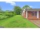 Side view of brick home featuring a well-manicured lawn and garden at 5436 Ahyoka Dr, Morrow, GA 30260