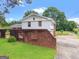 Two-story home featuring a brick wall on a lush green lawn under a bright blue sky with fluffy clouds at 5436 Ahyoka Dr, Morrow, GA 30260