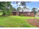 View of the front of a charming two-story home with a unique brick wall and landscaped yard at 5436 Ahyoka Dr, Morrow, GA 30260