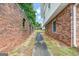 Side view of the house with brick wall alongside a walkway with green foliage and blue sky at 5436 Ahyoka Dr, Morrow, GA 30260
