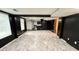 Open basement area with contemporary flooring, black accent walls and connection to the kitchen at 2325 Lochinver Sw Ln, Conyers, GA 30094