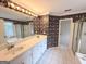 Bathroom with tub, shower, double vanity, and patterned wallpaper at 2325 Lochinver Sw Ln, Conyers, GA 30094