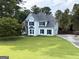 Classic two-story home with a well-manicured lawn and mature trees at 2325 Lochinver Sw Ln, Conyers, GA 30094