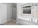 Bright bathroom with a large soaking tub and a glass-enclosed shower at 2565 Aaron Ct, Loganville, GA 30052