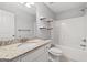 Bathroom with a granite countertop vanity, toilet, tub, and decorative shelves at 2565 Aaron Ct, Loganville, GA 30052