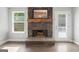 A stone fireplace, featuring a rustic wooden mantel, is the focal point of the living space at 2565 Aaron Ct, Loganville, GA 30052
