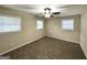 Neutral bedroom with plush carpeting and three bright windows, plus ceiling fan with light at 4385 Midway Rd, Douglasville, GA 30134