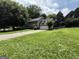 Charming two-story home with a lush green lawn and a long driveway leading to the garage at 5156 Allison Way, Sugar Hill, GA 30518