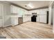 Spacious kitchen with white cabinets, stainless steel appliances, and wood-look flooring, ideal for home cooking at 5156 Allison Way, Sugar Hill, GA 30518