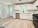 Open-concept kitchen with white cabinetry, stainless steel appliances, and modern flooring, creating a welcoming space at 5156 Allison Way, Sugar Hill, GA 30518