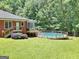 Backyard with above-ground pool and lush green grass and surrounded by trees at 543 Wynn Rd, Mcdonough, GA 30252