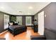 Cozy bedroom with dark walls, hardwood flooring, and windows with blinds, furnished with a black bed and dresser at 543 Wynn Rd, Mcdonough, GA 30252