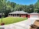 Beautiful home with a detached garage, featuring a well-kept lawn and inviting landscaping at 543 Wynn Rd, Mcdonough, GA 30252