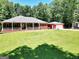 Inviting home with a lush green lawn, a detached garage, and a charming covered front porch at 543 Wynn Rd, Mcdonough, GA 30252