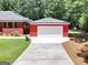 Detached garage with white door and red siding, complemented by a concrete driveway at 543 Wynn Rd, Mcdonough, GA 30252