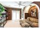 Comfortable living room with brown walls, arched feature, built-in shelves and a plush couch with a ceiling fan at 543 Wynn Rd, Mcdonough, GA 30252