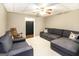 Cozy living room with a plush sectional sofa, carpeted floors, and a wooden rocking chair, illuminated by a ceiling fan at 543 Wynn Rd, Mcdonough, GA 30252