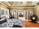 Well-lit main bedroom featuring hardwood floors, a ceiling fan, and a doorway to the main bathroom at 543 Wynn Rd, Mcdonough, GA 30252