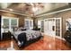 Bright main bedroom featuring hardwood floors, a ceiling fan, and double doors leading to the main bath at 543 Wynn Rd, Mcdonough, GA 30252