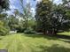 Lush backyard with mature trees and lawn at 402 Stone St, Oxford, GA 30054