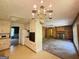 Kitchen with white cabinetry, appliances, chandelier, open to fireplace living room at 402 Stone St, Oxford, GA 30054