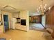 Kitchen with white cabinetry, appliances, chandelier, open to fireplace living room at 402 Stone St, Oxford, GA 30054