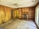 Living room with wood paneling, brick fireplace, built-in shelves, ceiling fan at 402 Stone St, Oxford, GA 30054