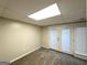 Finished basement area with neutral carpet and glass door leading to the outside, freshly painted walls at 5670 Bob White Ln, Douglasville, GA 30135