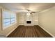 Spacious living room featuring hardwood floors, a ceiling fan, and a decorative fireplace with built-in shelving at 5670 Bob White Ln, Douglasville, GA 30135