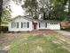 Single-story house featuring a red door, neutral siding, black shutters, and an attached garage at 410 Tarragon Sw Way, Atlanta, GA 30331