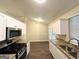 Bright kitchen showcasing white cabinets, granite countertops, and stainless steel appliances at 410 Tarragon Sw Way, Atlanta, GA 30331
