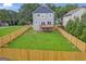 Backyard featuring a wood fence, green grass, mature trees and a wooden deck on the gray home at 583 Whitaker Nw St, Atlanta, GA 30318