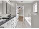 Bathroom with double vanity, bathtub, and neutral tiling creating a clean and functional space at 583 Whitaker Nw St, Atlanta, GA 30318