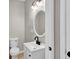 Clean half-bath with white vanity, modern faucet, and a decorative oval mirror at 583 Whitaker Nw St, Atlanta, GA 30318
