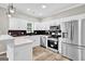 Modern kitchen features white cabinets, quartz countertops, stainless steel appliances, and black tile backsplash at 583 Whitaker Nw St, Atlanta, GA 30318